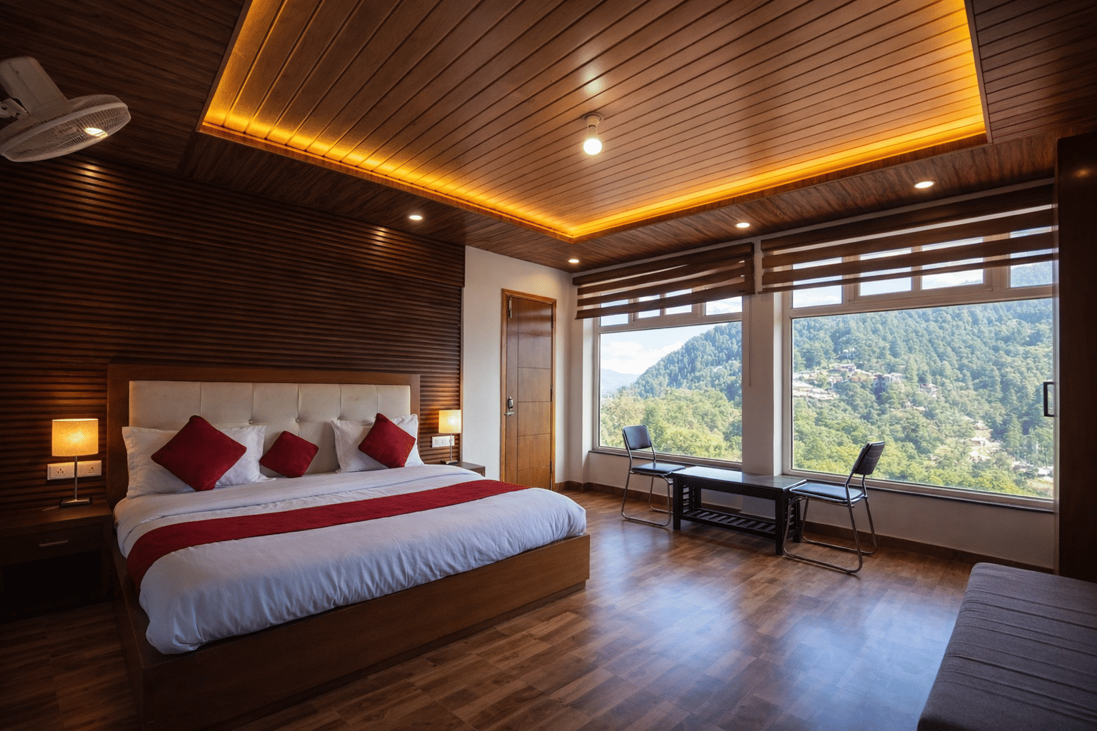 A wood-panelled guest room with a valley view at JPT Hotels