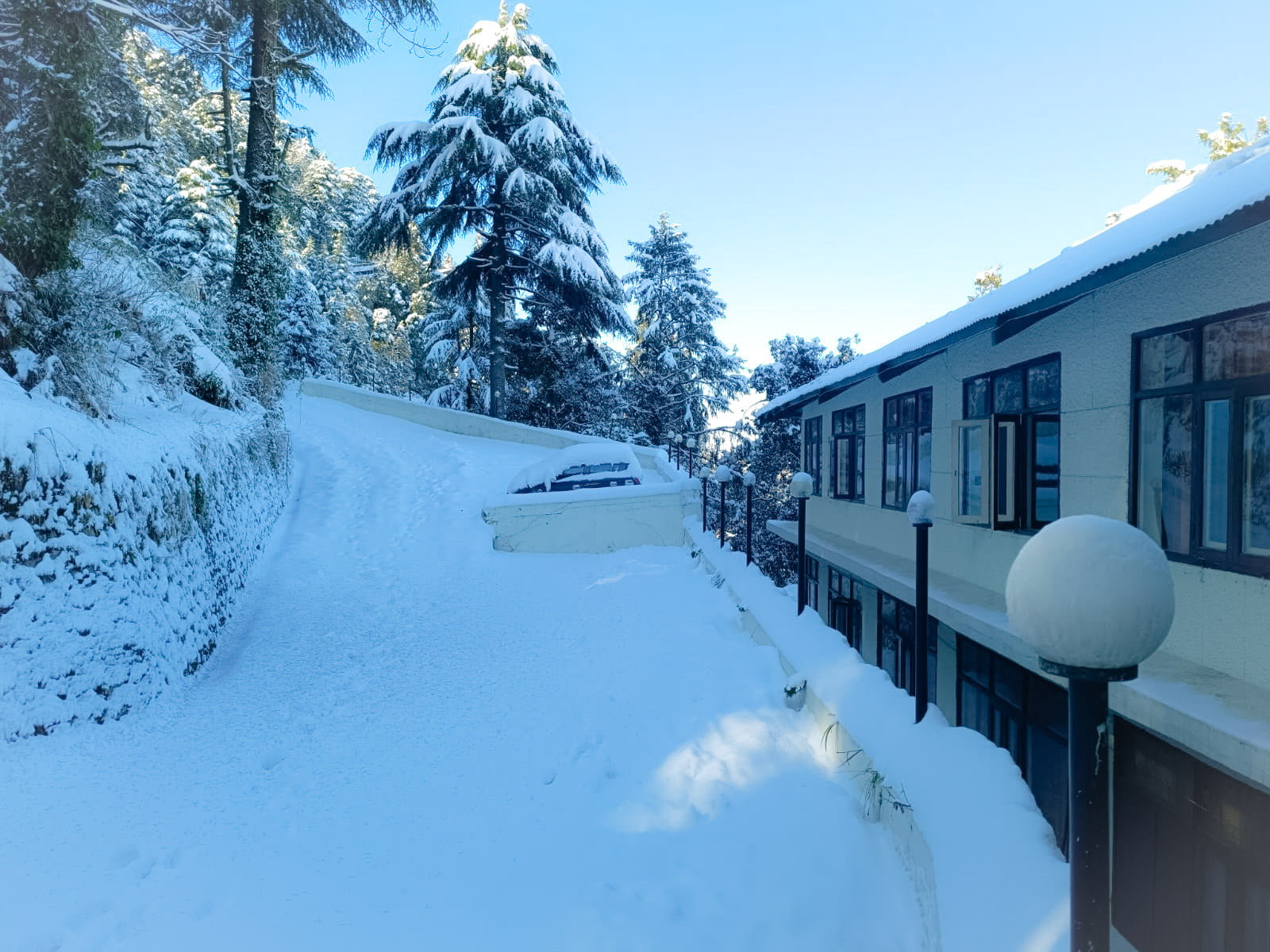A snow-covered path beside a JPT hotel in Dalhousie in winter
