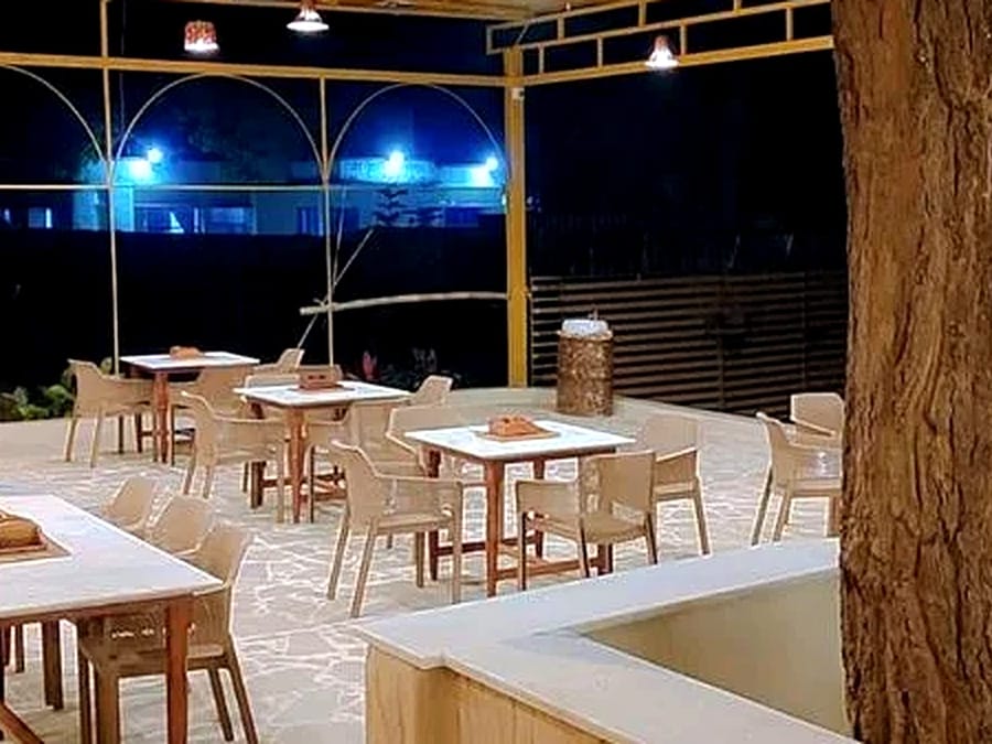 Outdoor tables lit for dinner at Signum Resort, Bandhavgarh