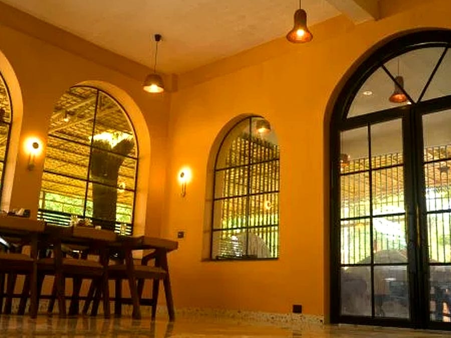 The dining room and its arched windows at Signum Resort, Bandhavgarh