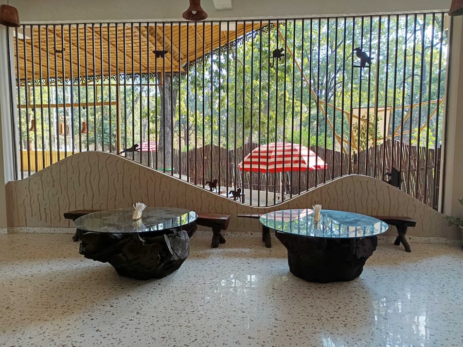 Live-edge tables looking out to the garden at Signum Resort, Bandhavgarh