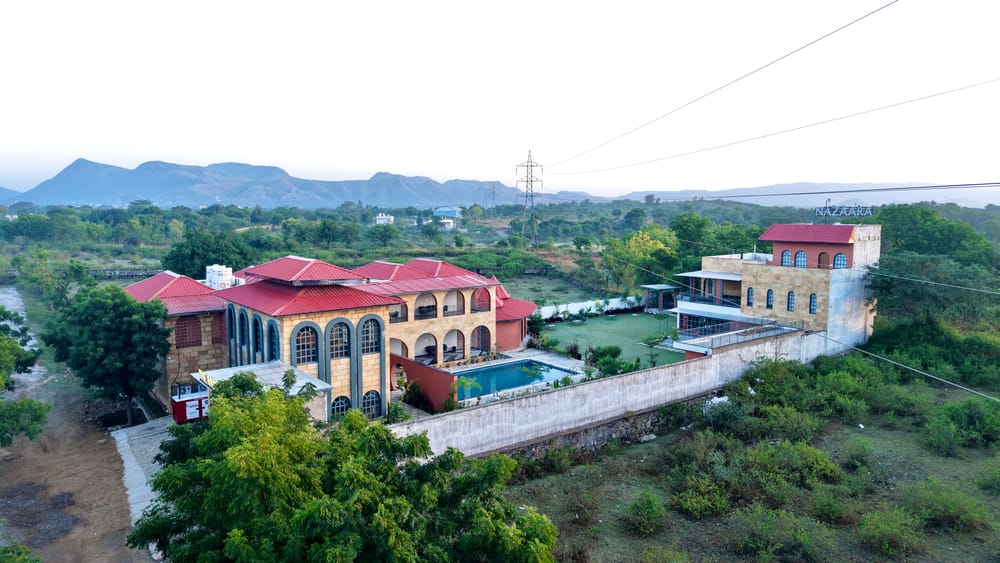 Aerial view of Nazaara Hills Retreat, Udaipur, showing the resort's layout amid the Aravalli hills