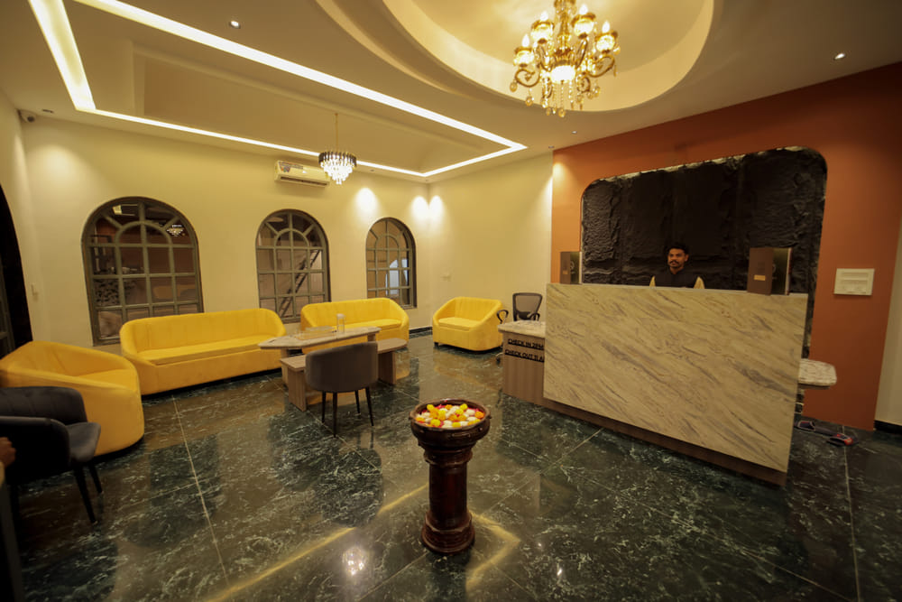 Reception desk at Nazaara Hills Retreat, Udaipur, styled with a floral urn beside the check-in counter.