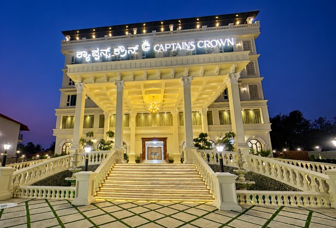 The pillared entrance of Captains Crown Hotels and Resorts, lit up at dusk