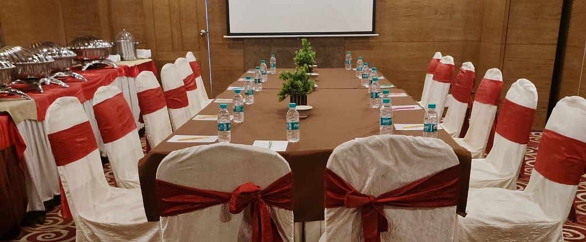 A conference room arranged for a meeting with red chairs and a patterned carpet - The President Hotel Jayanagar, Bangalore