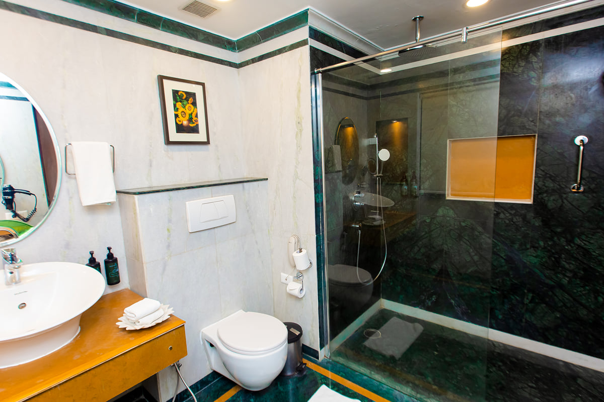 Deluxe Room bathroom with a glass shower at Ramada by Wyndham Udaipur Resort and Spa