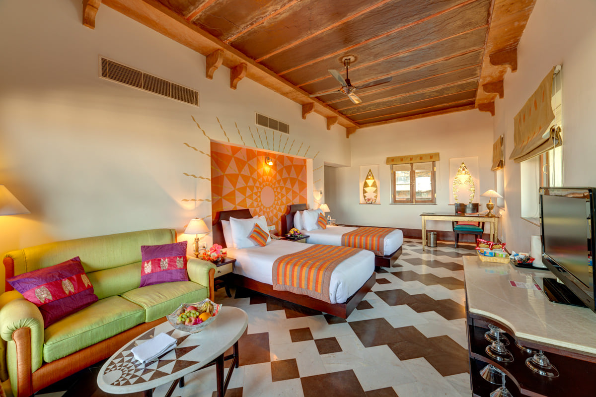Premium Room with twin beds and a sofa at Ramada by Wyndham Udaipur Resort and Spa