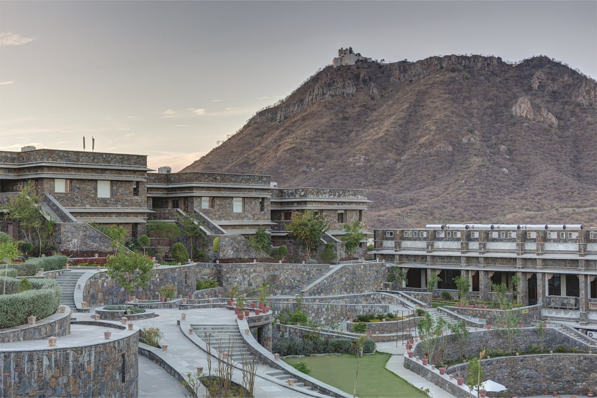 Hotels near Sajjangarh Fort: the stone buildings of Ramada by Wyndham Udaipur Resort and Spa below a hilltop fort