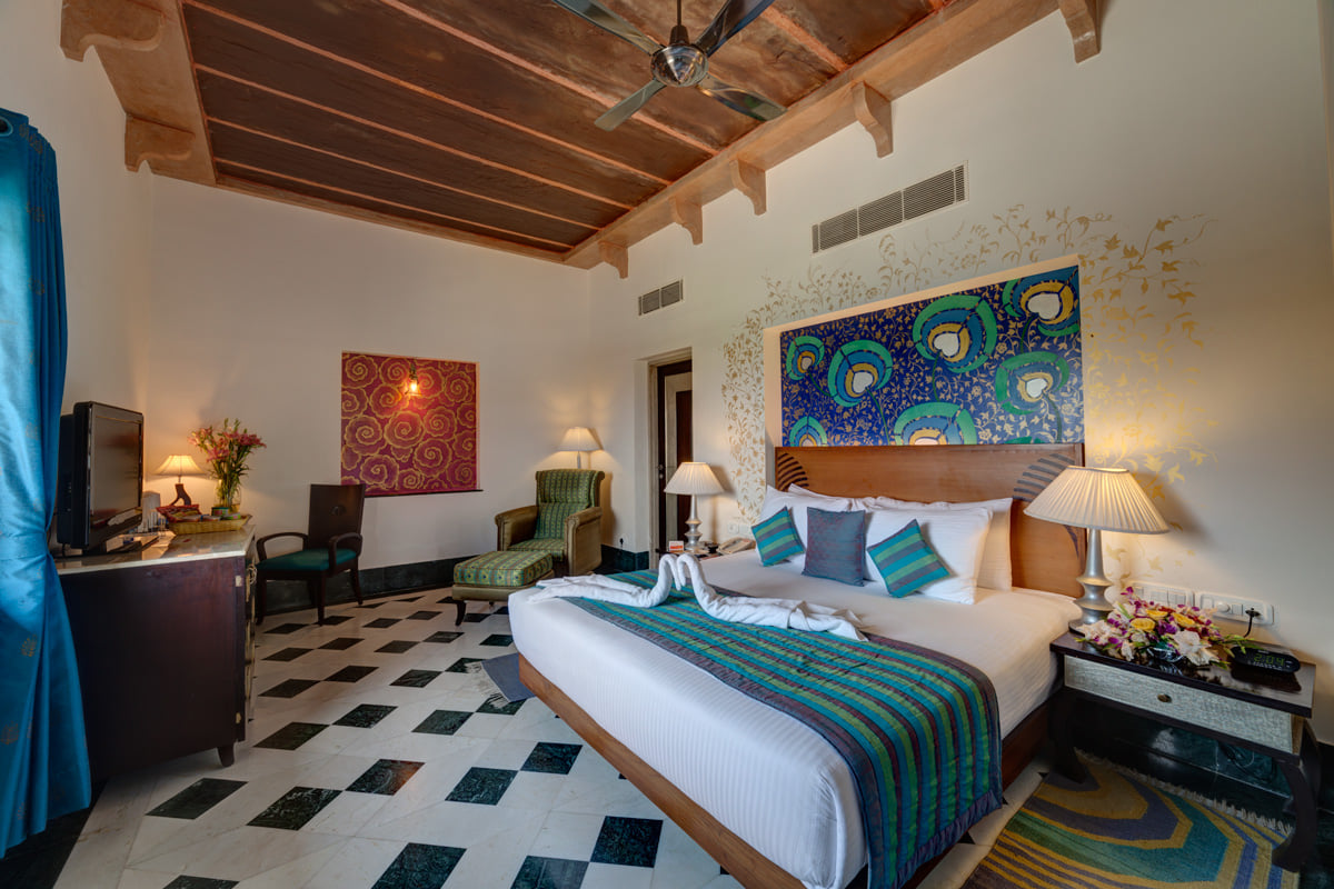 Suite bedroom with peacock artwork at Ramada by Wyndham Udaipur Resort and Spa