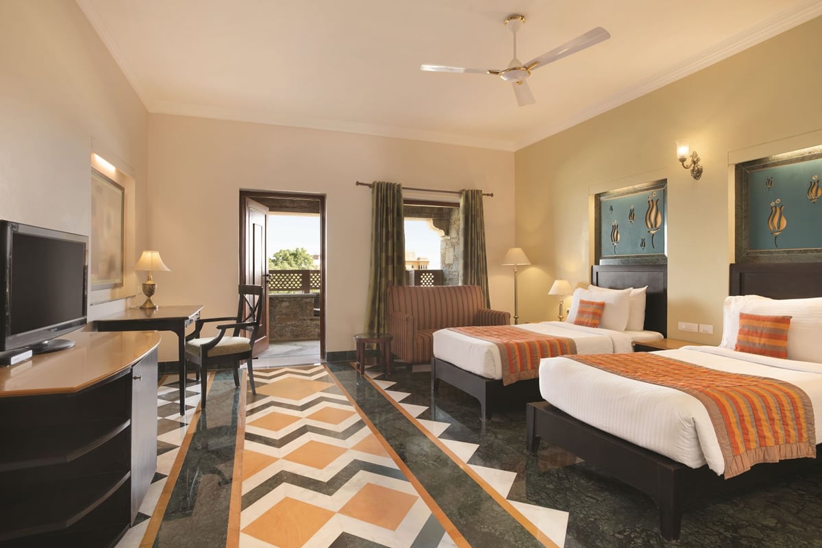 Super Deluxe Room with twin beds and a desk at Ramada by Wyndham Udaipur Resort and Spa