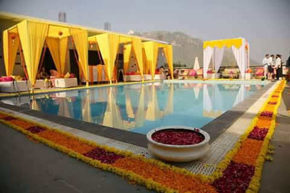 A poolside wedding with yellow canopy decor at Ramada by Wyndham Udaipur Resort and Spa