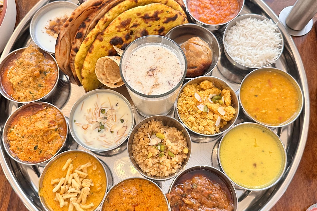 A Rajasthani thali dinner served by the pool at Ramada by Wyndham Udaipur Resort and Spa