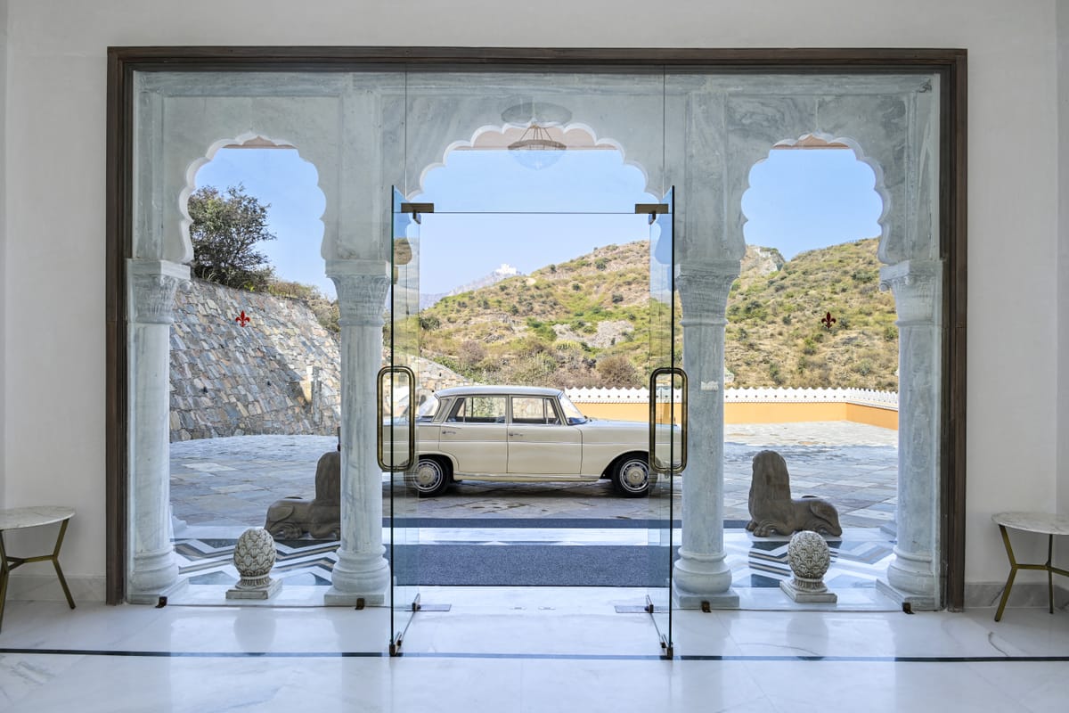 A classic Mercedes-Benz saloon framed in the arched entrance at Fateh Vilas, Udaipur