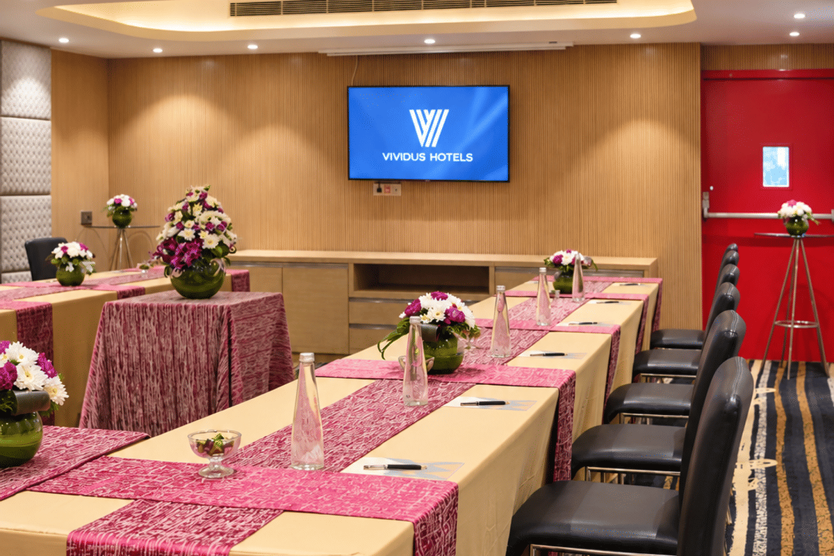 Zang meeting room with tables set in rows and a wall screen