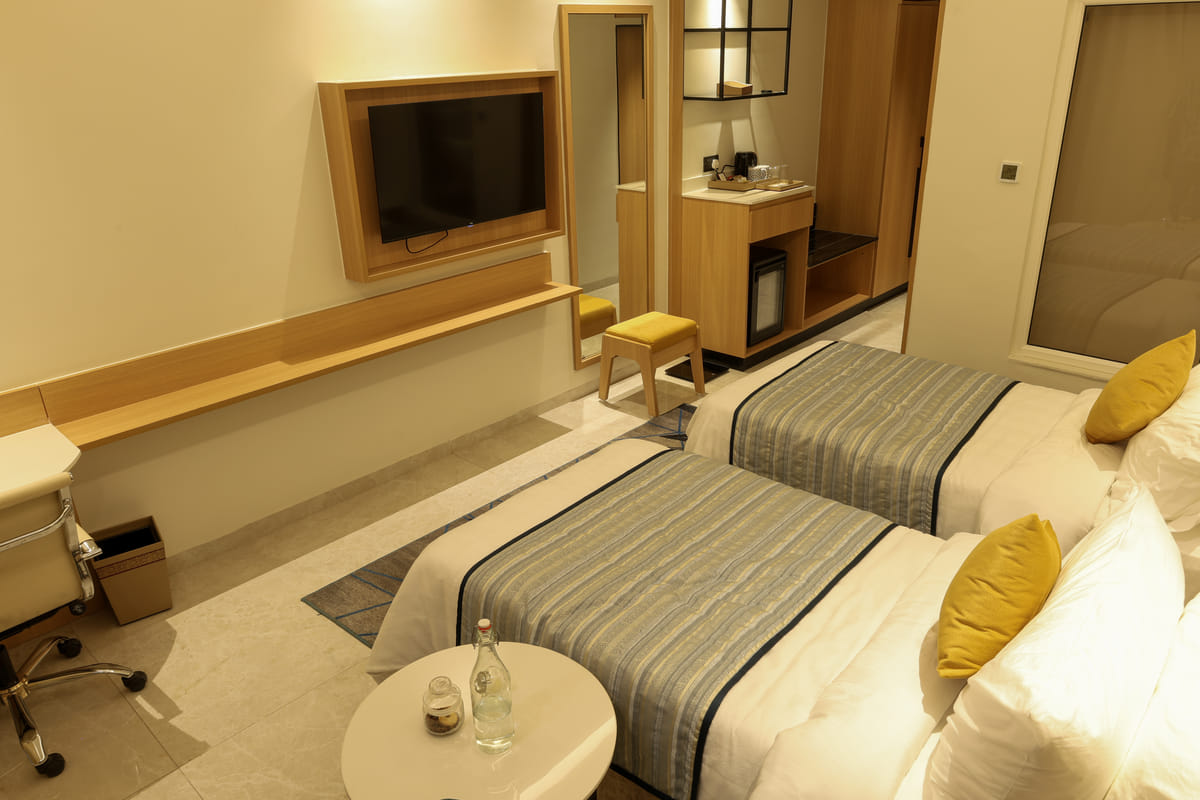 Twin beds and work desk in the garden-facing Executive Twin room, OMR Chennai