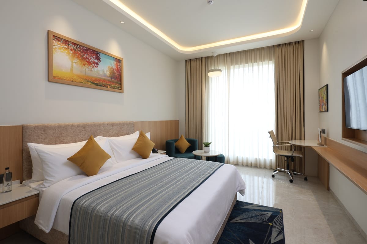 Executive King room with a king bed, work desk and city view at Triumph Regency OMR Chennai