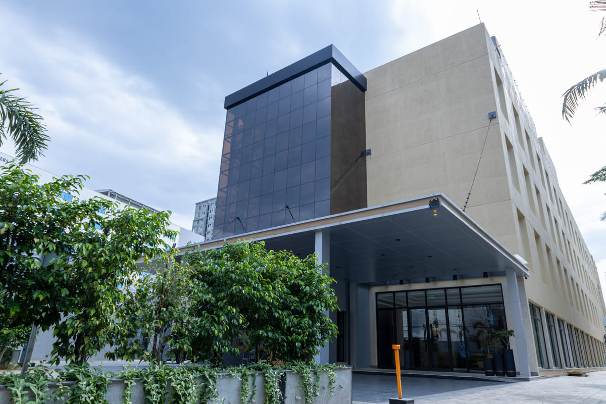 Glass-fronted facade of Triumph Regency OMR Chennai by day