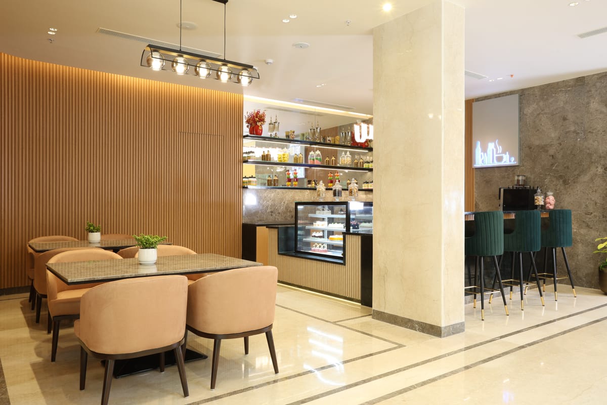 Coffee shop seating in the open lobby at Triumph Regency OMR Chennai