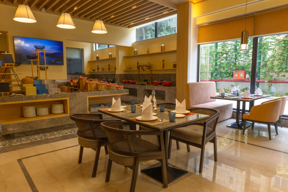 Table seating inside the multi-cuisine restaurant at OMR Chennai