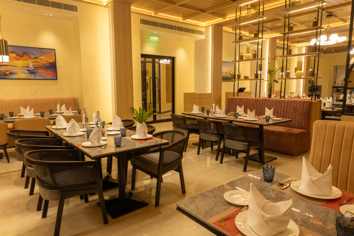 Indoor dining tables and chairs at the multi-cuisine restaurant, Triumph Regency OMR Chennai