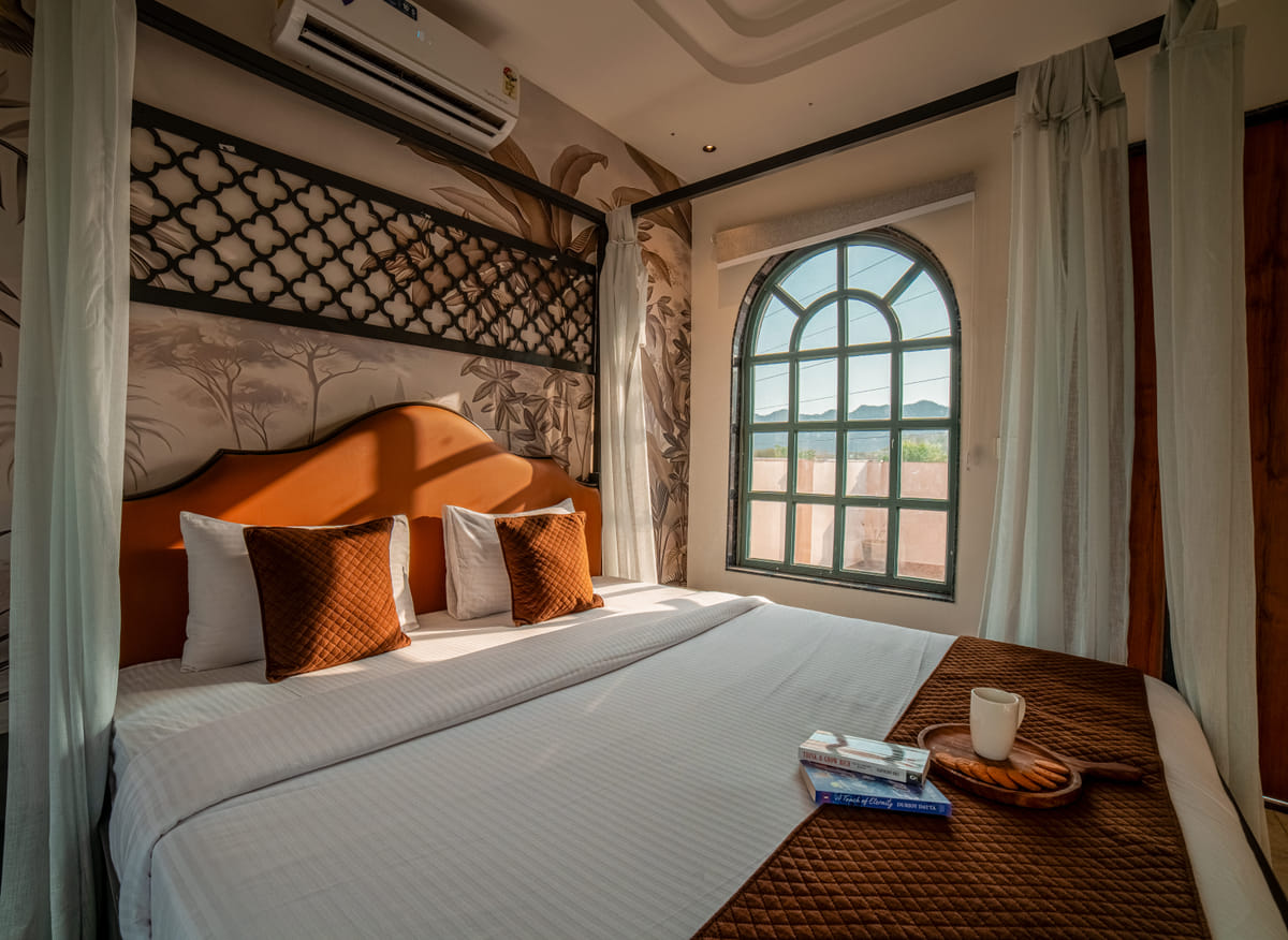 Botanical mural headboard behind a canopy bed in the Nazaara Royal Suite at Nazaara Hills Retreat, Udaipur