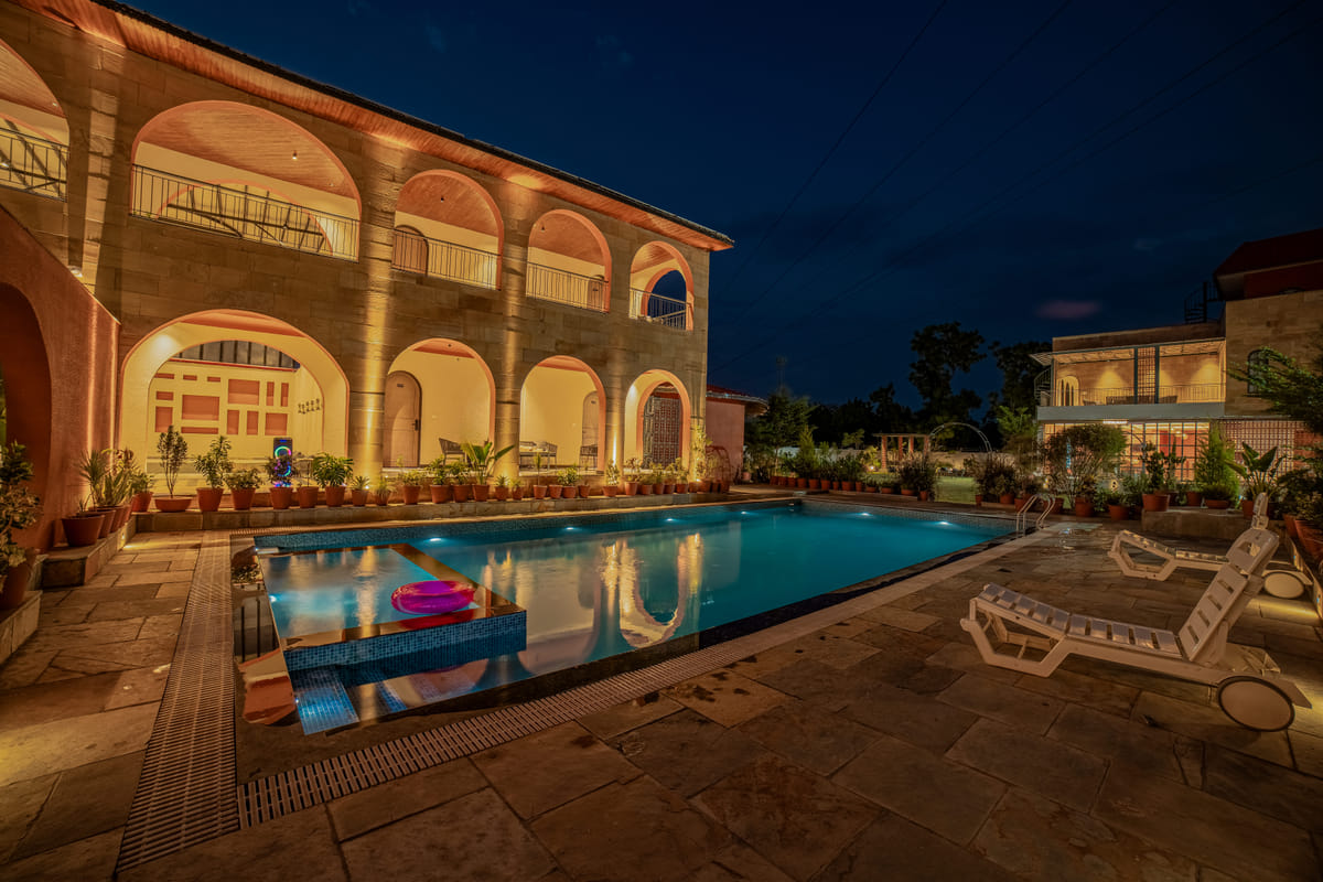 Nazaara Hills Retreat, Udaipur, pool deck lit at night with a raised spa nook