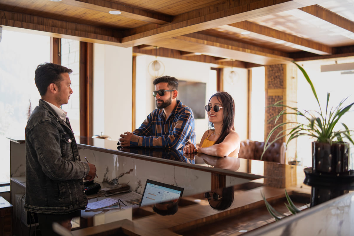 Staff checking in guests at Nazaara Luxe Retreat, Manali