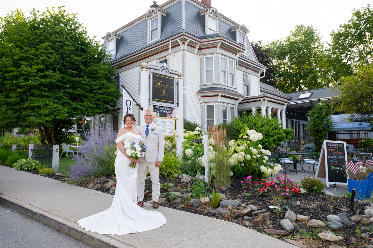 A newly married couple outside the Hartstone Inn in Camden, Maine, framed by summer gardens