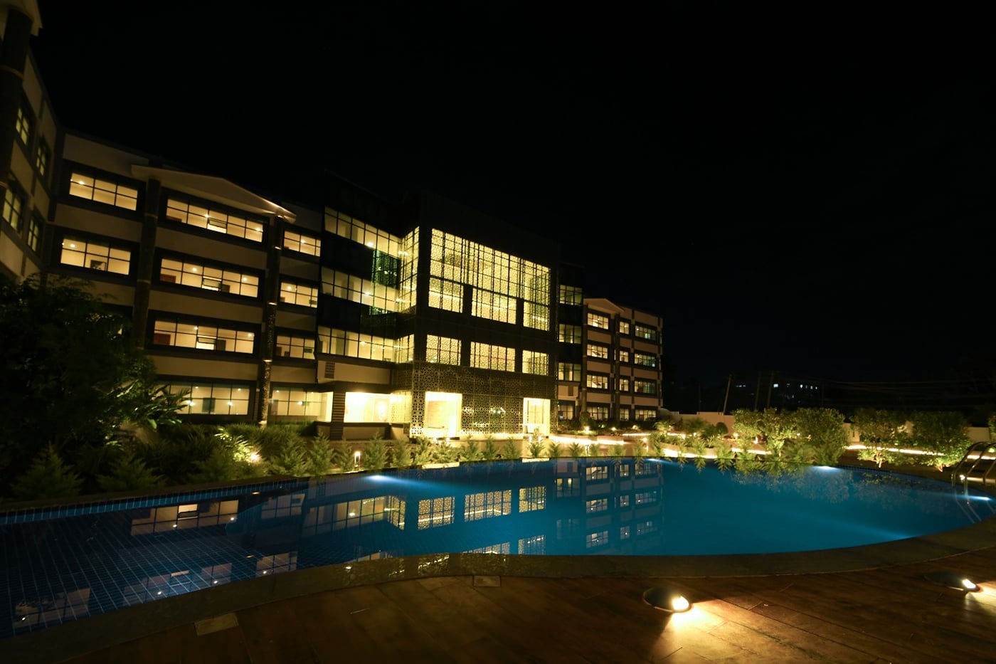 The hotel and swimming pool lit up at night