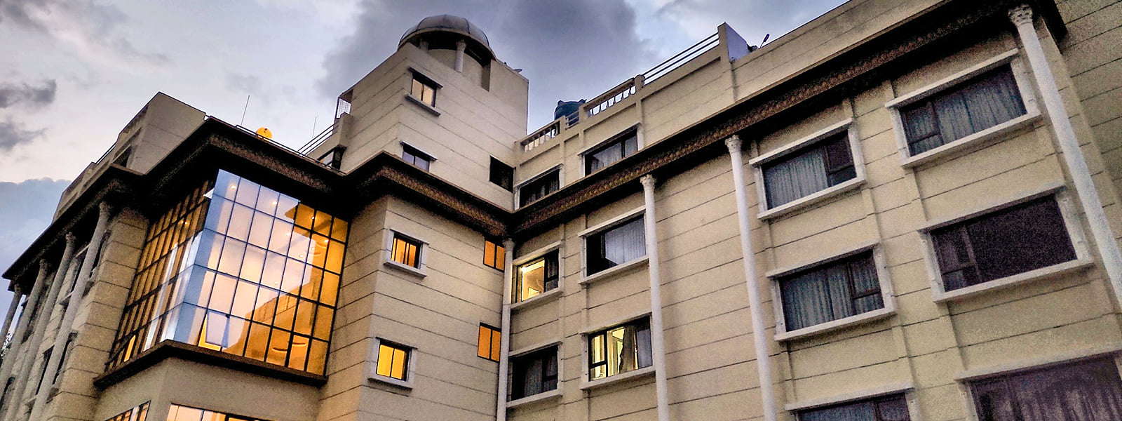 Hotel City Heart, Shirdi, facade at dusk with lights on