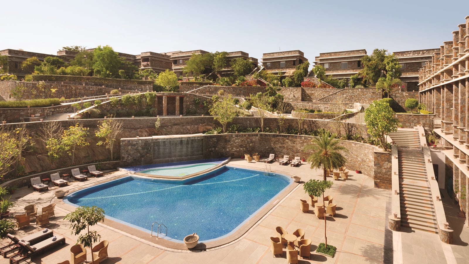 The courtyard pool with sun loungers at Ramada by Wyndham Udaipur Resort and Spa