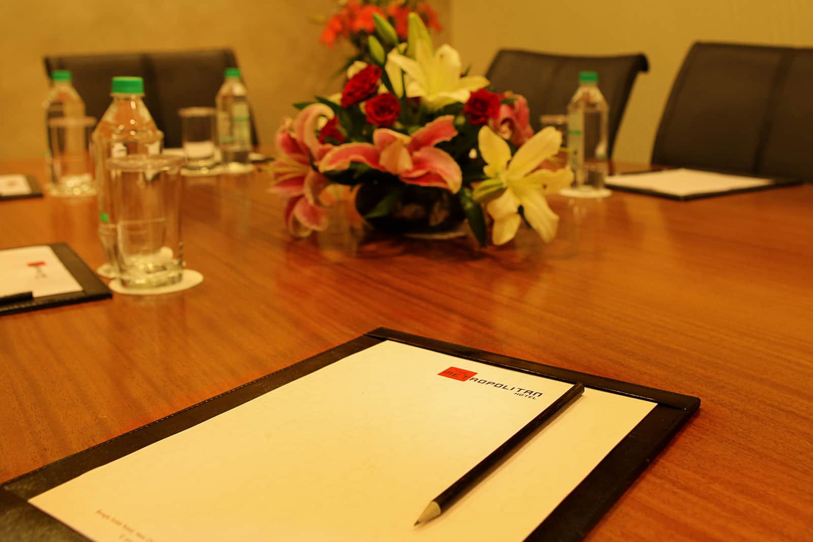 The boardroom table laid with pads and water