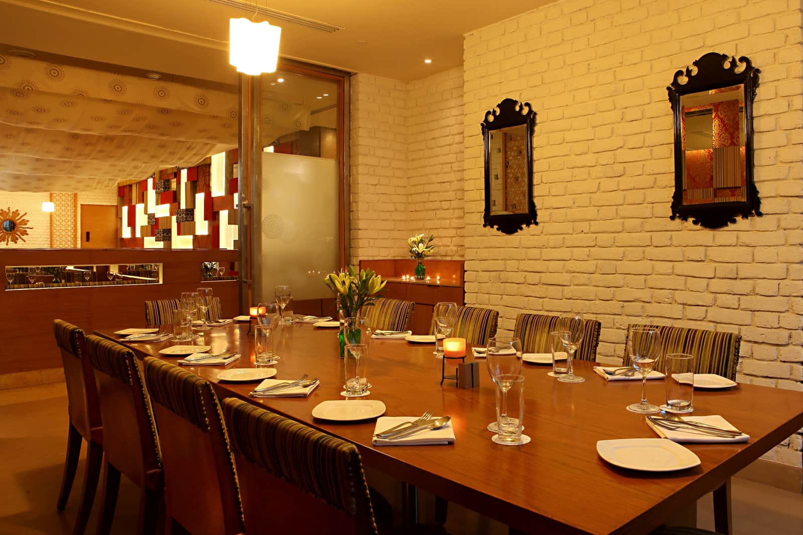 A long table laid for a group at Chutney, mirrors on the wall