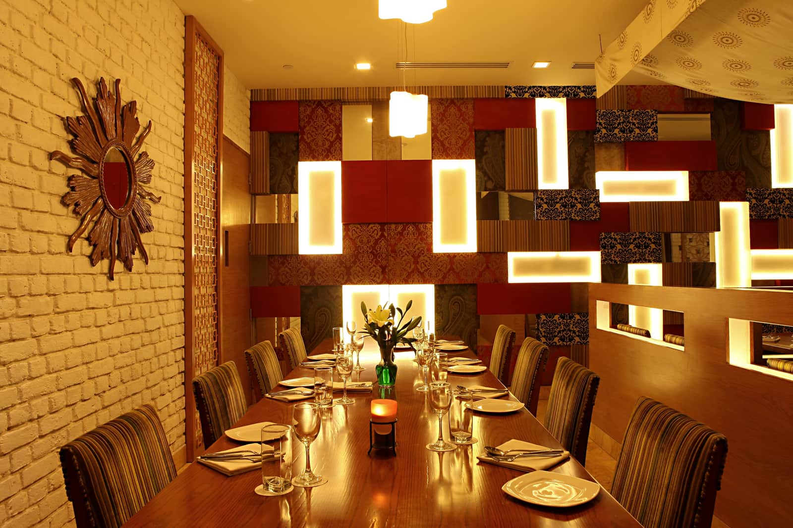 A table set against the brick wall under the backlit panels at Chutney