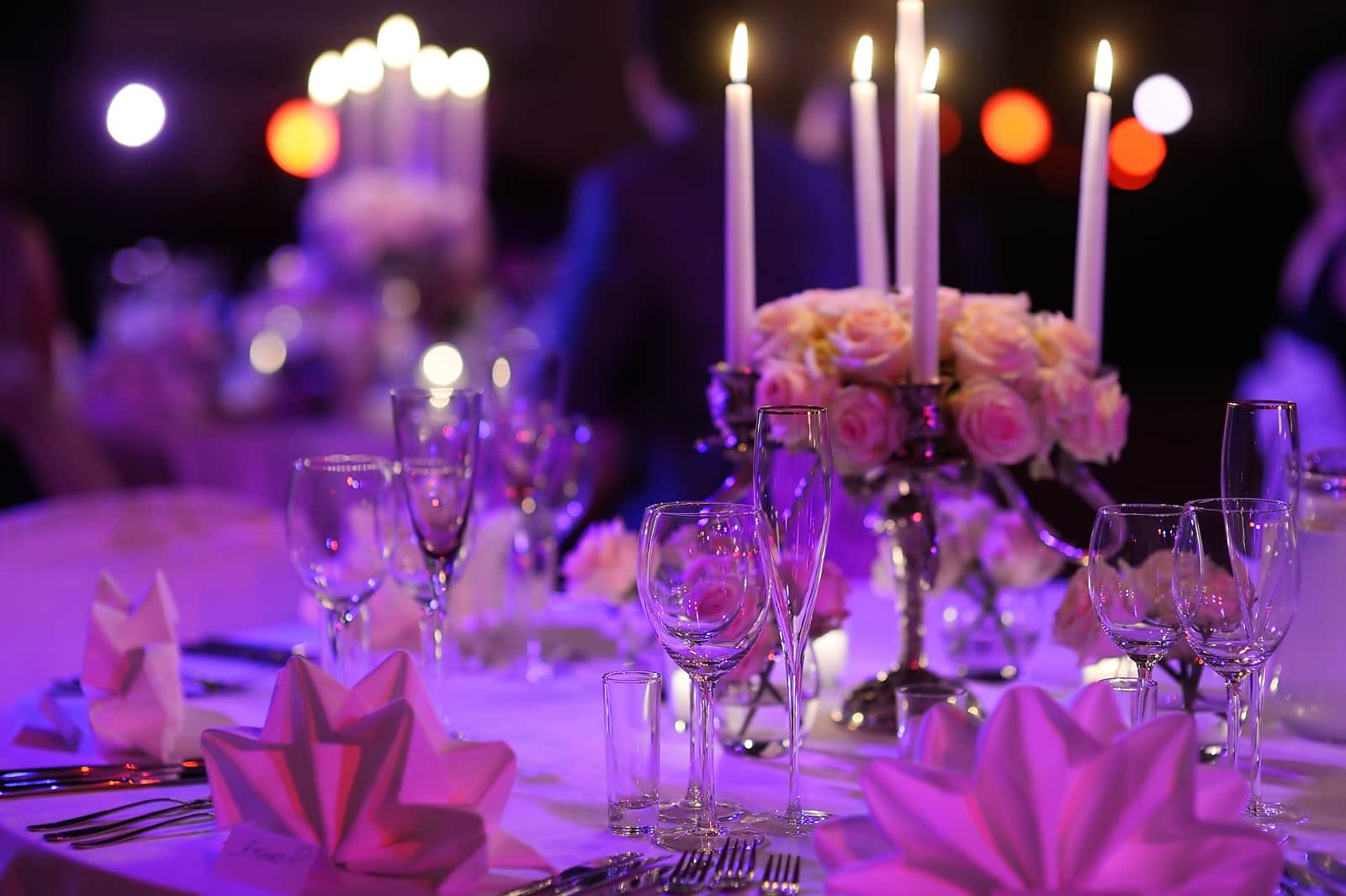 A candlelit table with a rose arrangement