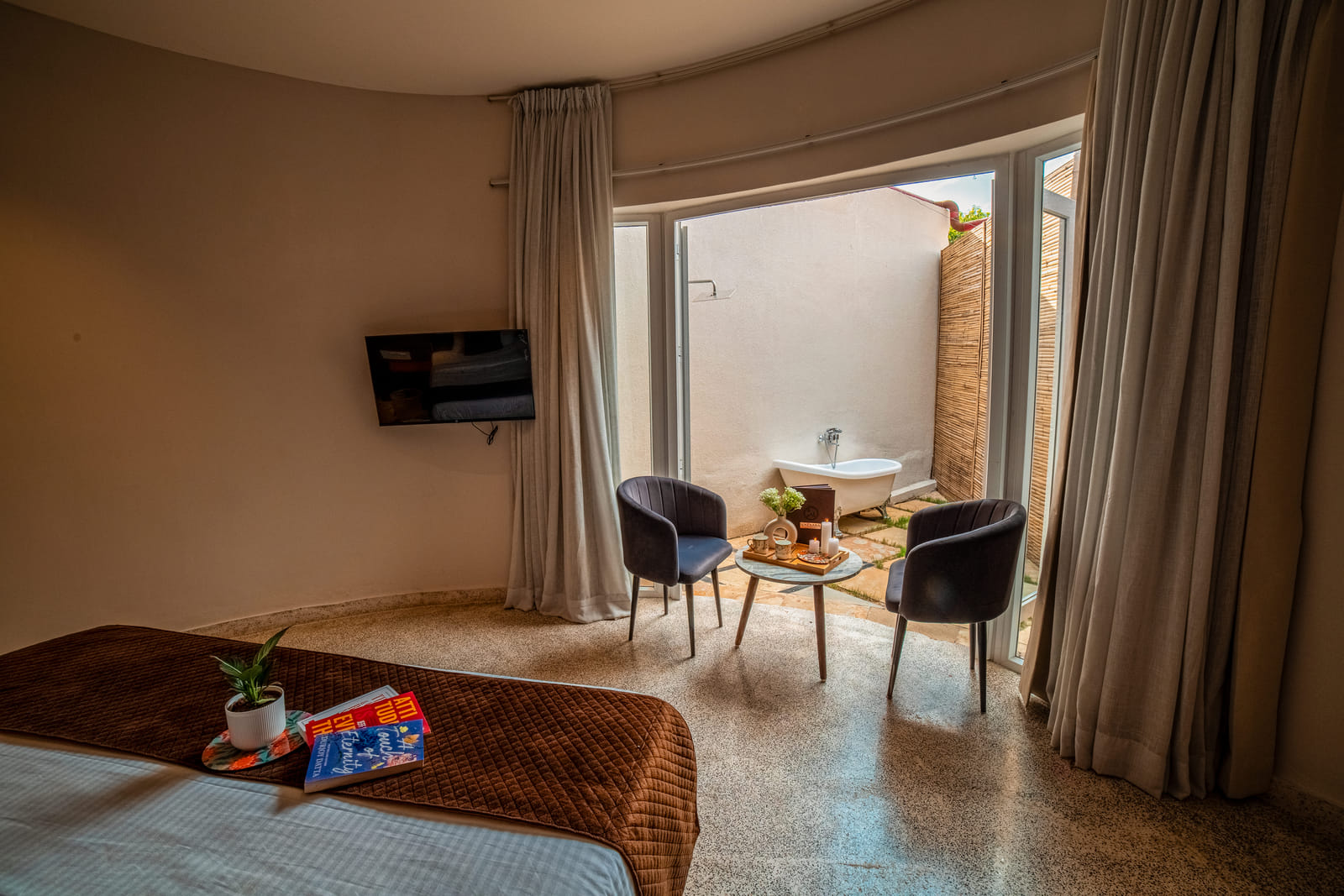 Luxurious Cabana Cottage bedroom opening onto a private patio at Nazaara Hills Retreat, Udaipur