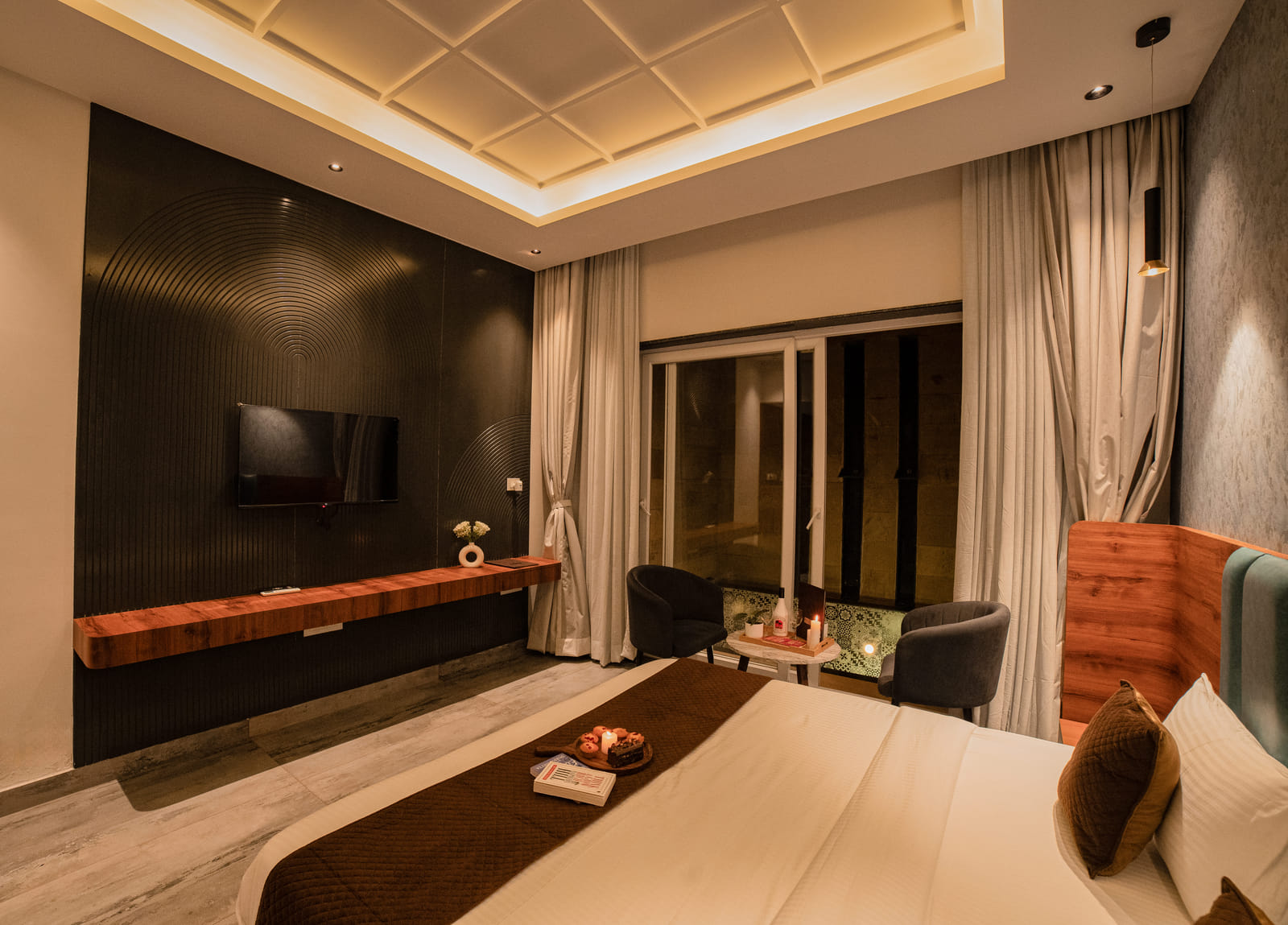 Wide view of the bed and TV wall in the Premium Plunge Pool Room at Nazaara Hills Retreat, Udaipur
