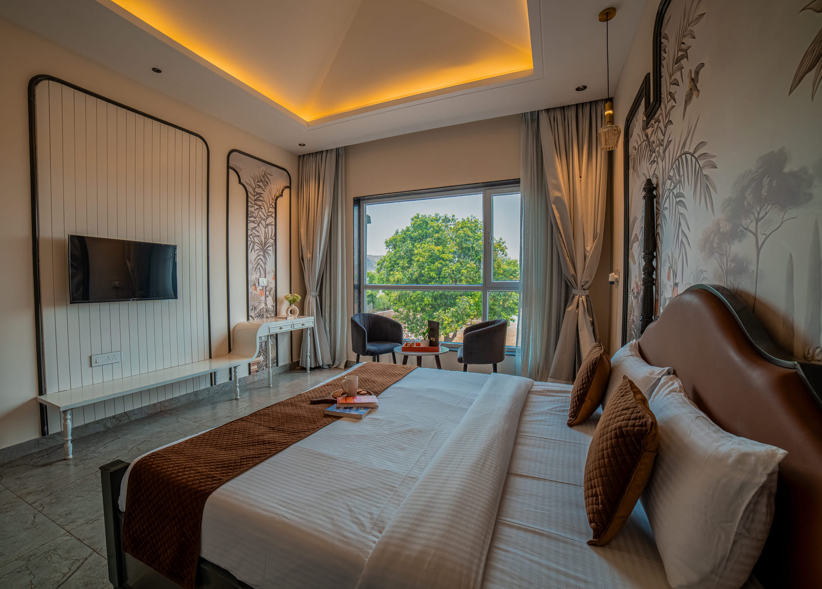Superior Room at Nazaara Hills Retreat, Udaipur, a neatly made king-size bed beside a window with mountain views