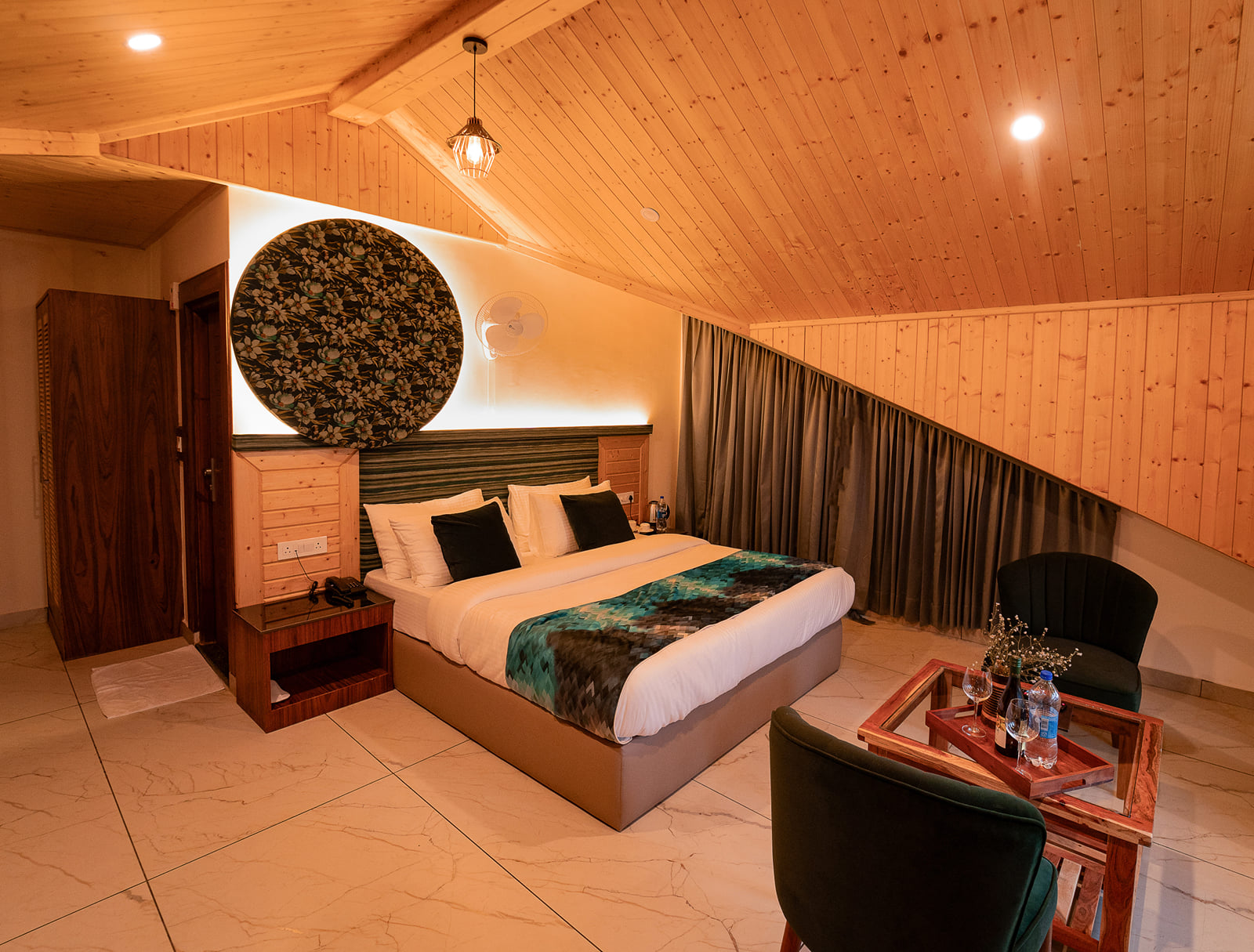 Bed set against a floral wall-art panel in the Nazaara Luxe Interconnected room at Nazaara Luxe Retreat, Manali