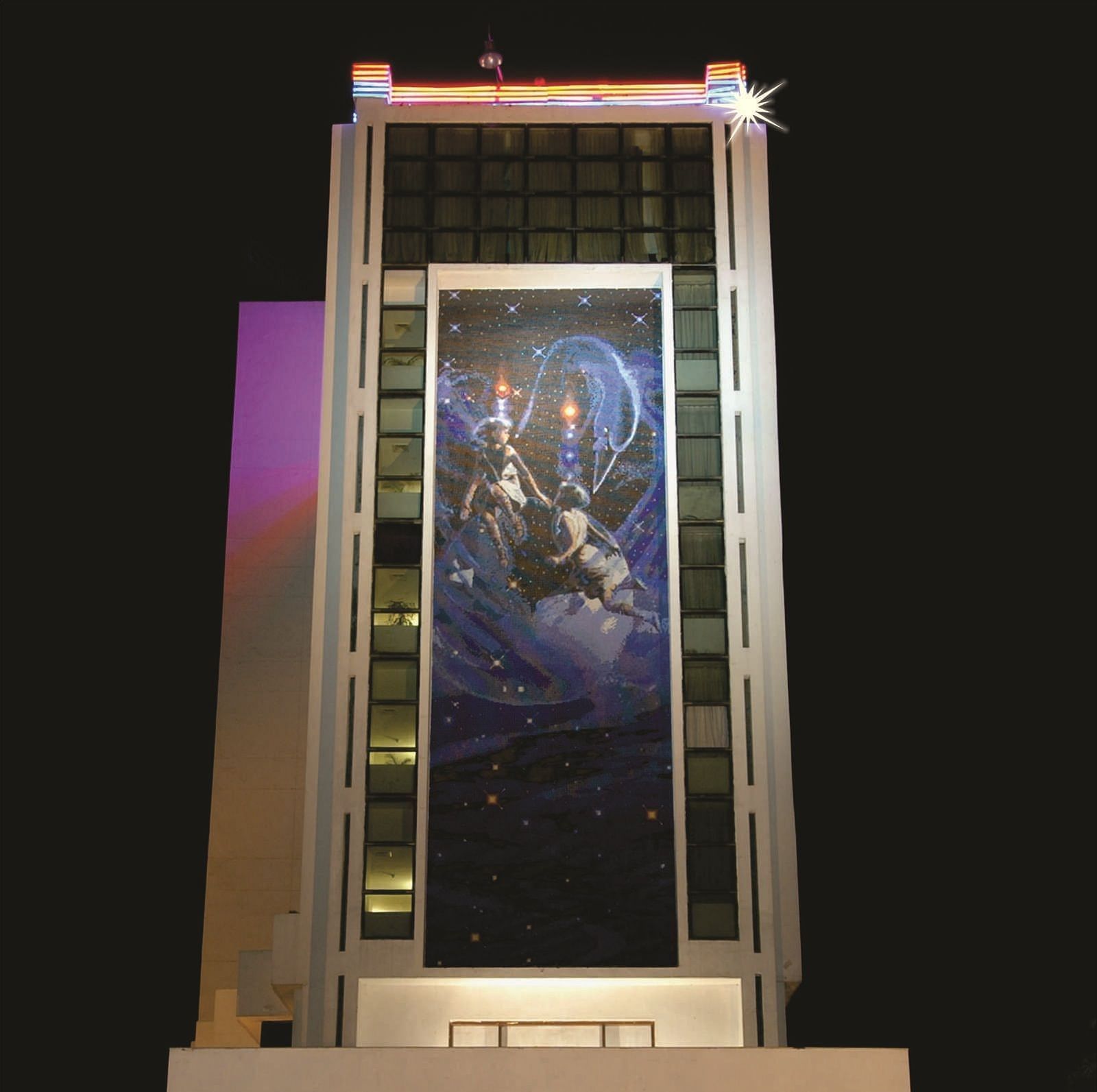 Facade of a night-time view of a modern hotel building illuminated with lights in the ground floor | Gemini Continental