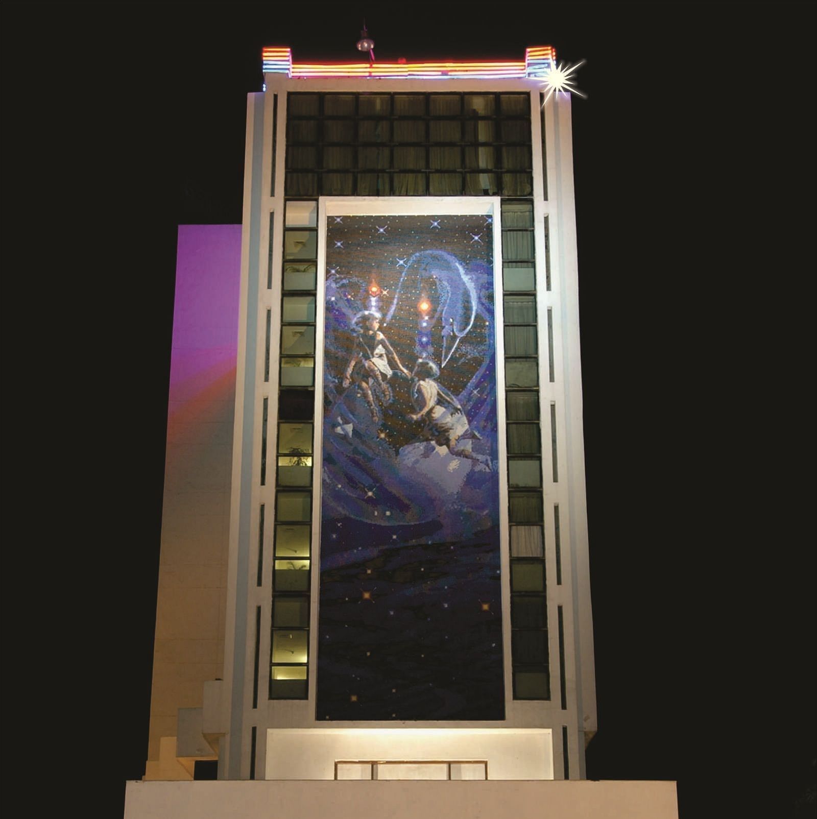 Facade of a night-time view of a modern hotel building illuminated with lights in the ground floor | Gemini Continental