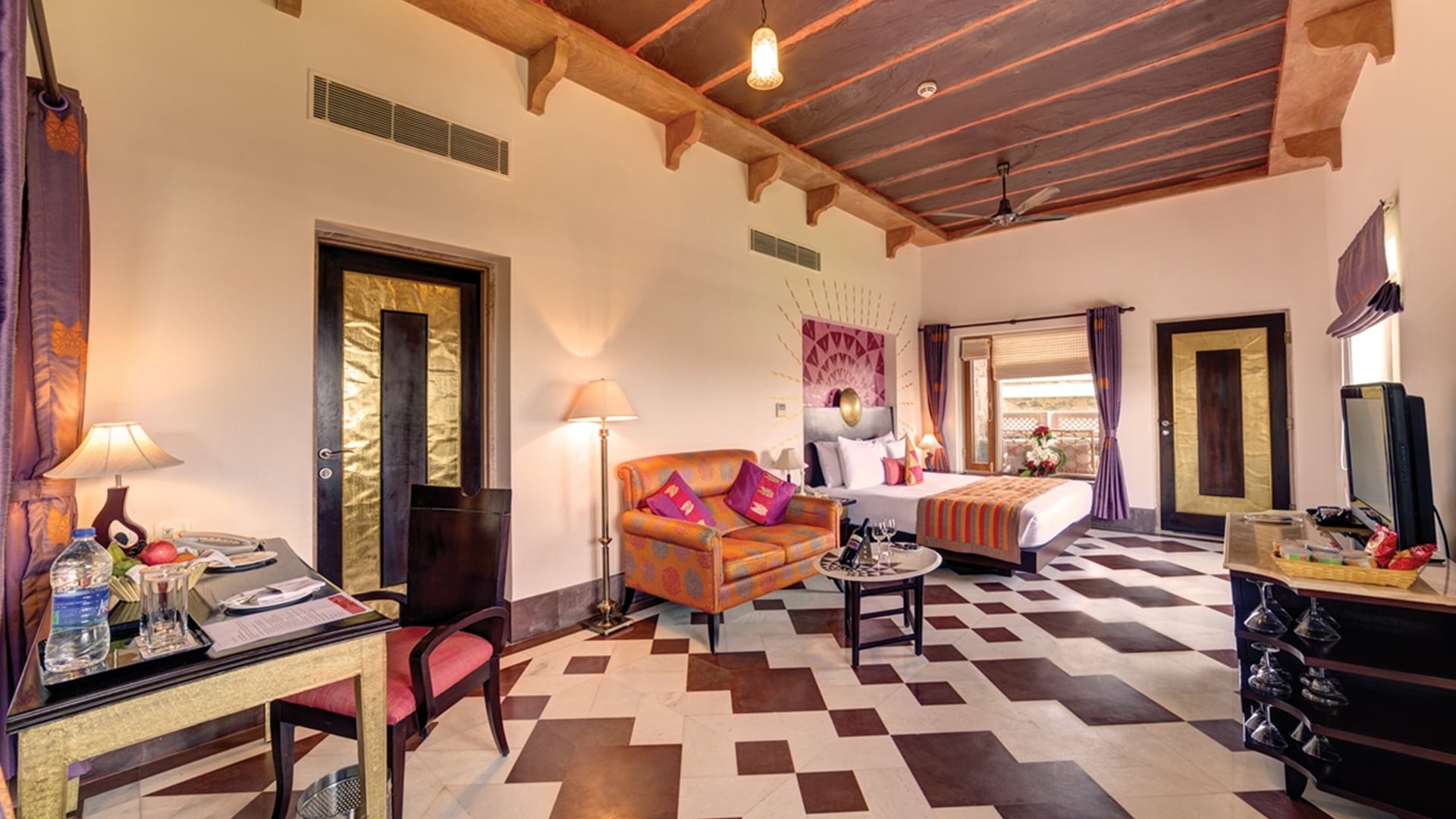 Rooms in Udaipur: a Premium Room with a bed, sofa and desk at Ramada by Wyndham Udaipur Resort and Spa