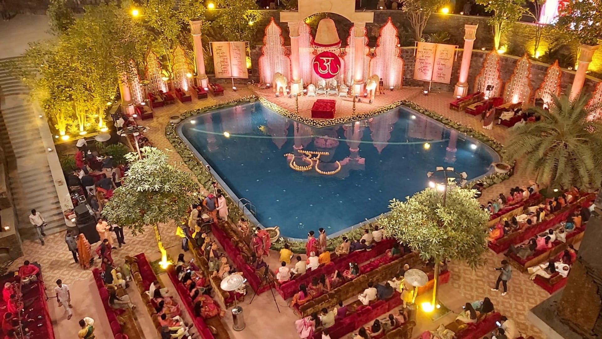 Destination wedding in Udaipur: a decorated stage and guest seating by the pool at Ramada by Wyndham Udaipur Resort and Spa