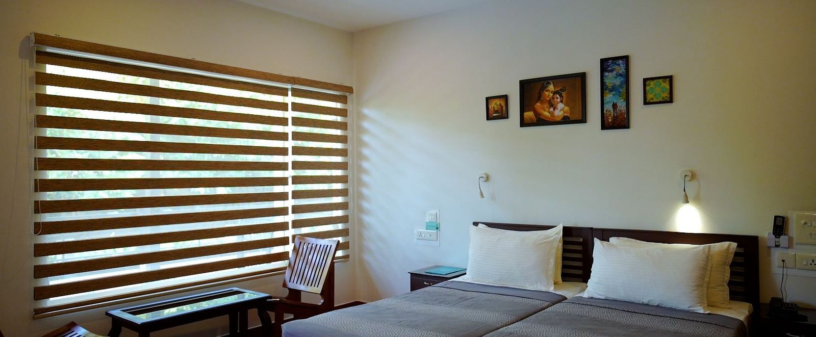 A simply furnished bedroom with a bed, desk, and window blinds.