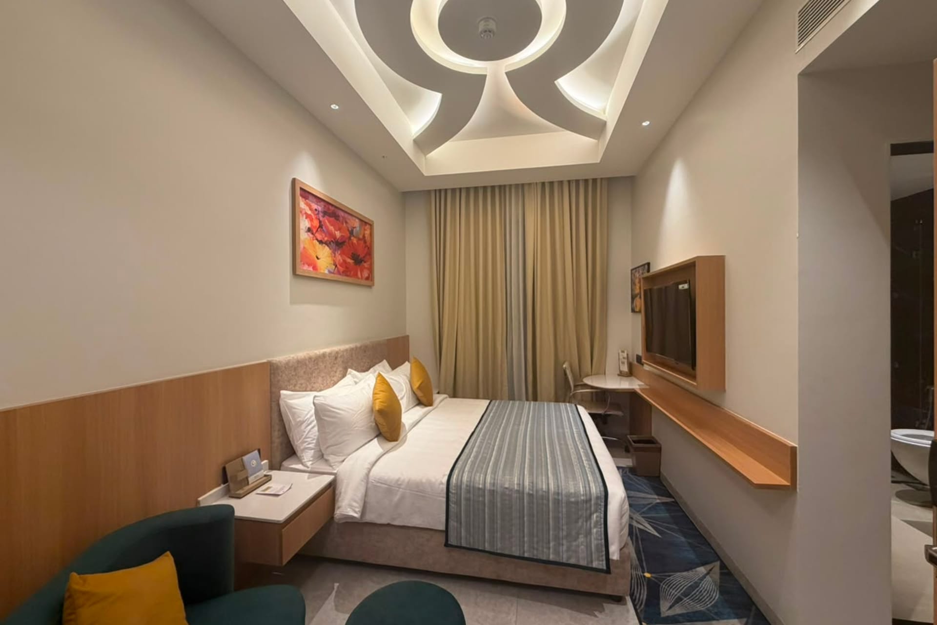 King bed by the window in the Smart Day Room at Triumph Regency OMR Chennai