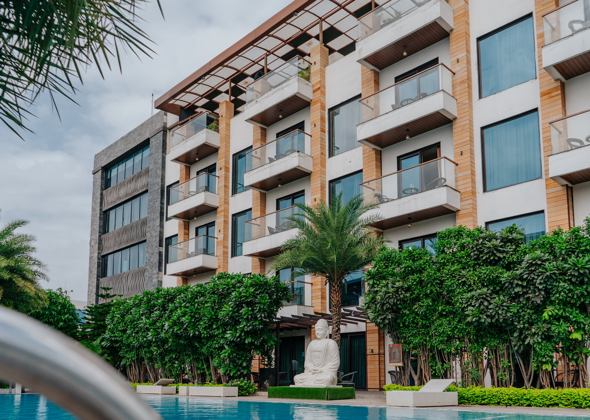 Skyline by Miraya location, facade on Indore Bypass, a multi-storey hotel with balconies beside a pool and garden