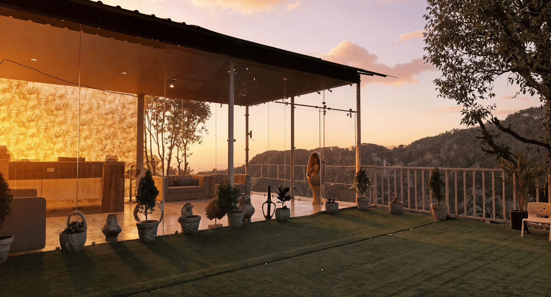 Glass-facade reception exterior at Nazaara Nature Retreat, Dalhousie, windows glowing amber as the sun sets behind the hills