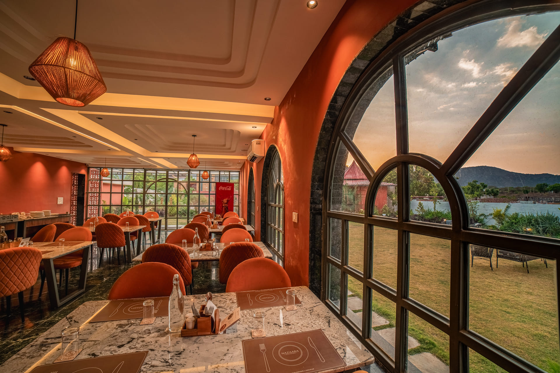 Fine-dine restaurant interior with arched windows at Nazaara Hills Retreat, Udaipur