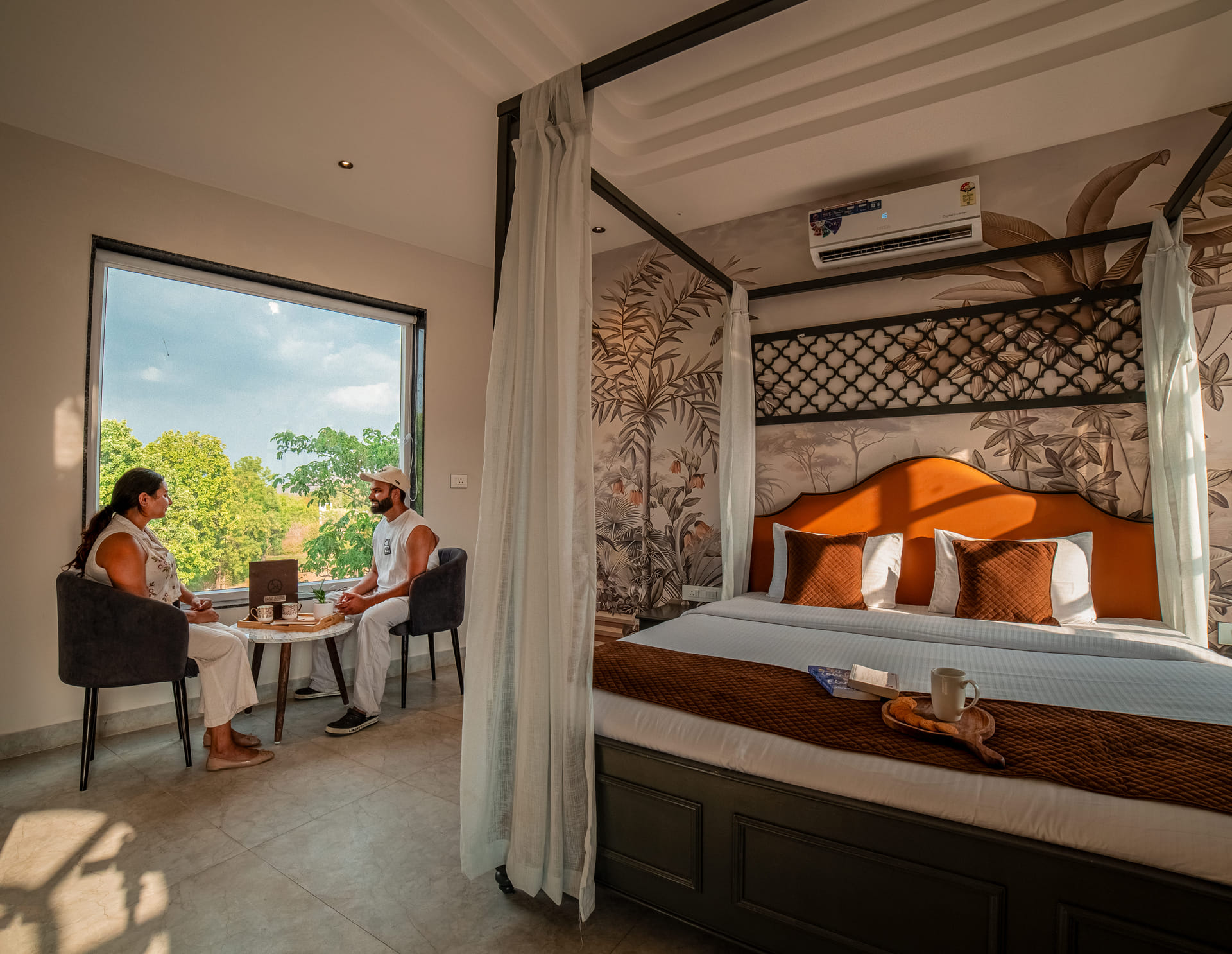 Nazaara Hills Retreat, Udaipur, couple by the window in the Royal Suite's canopy bed lounge