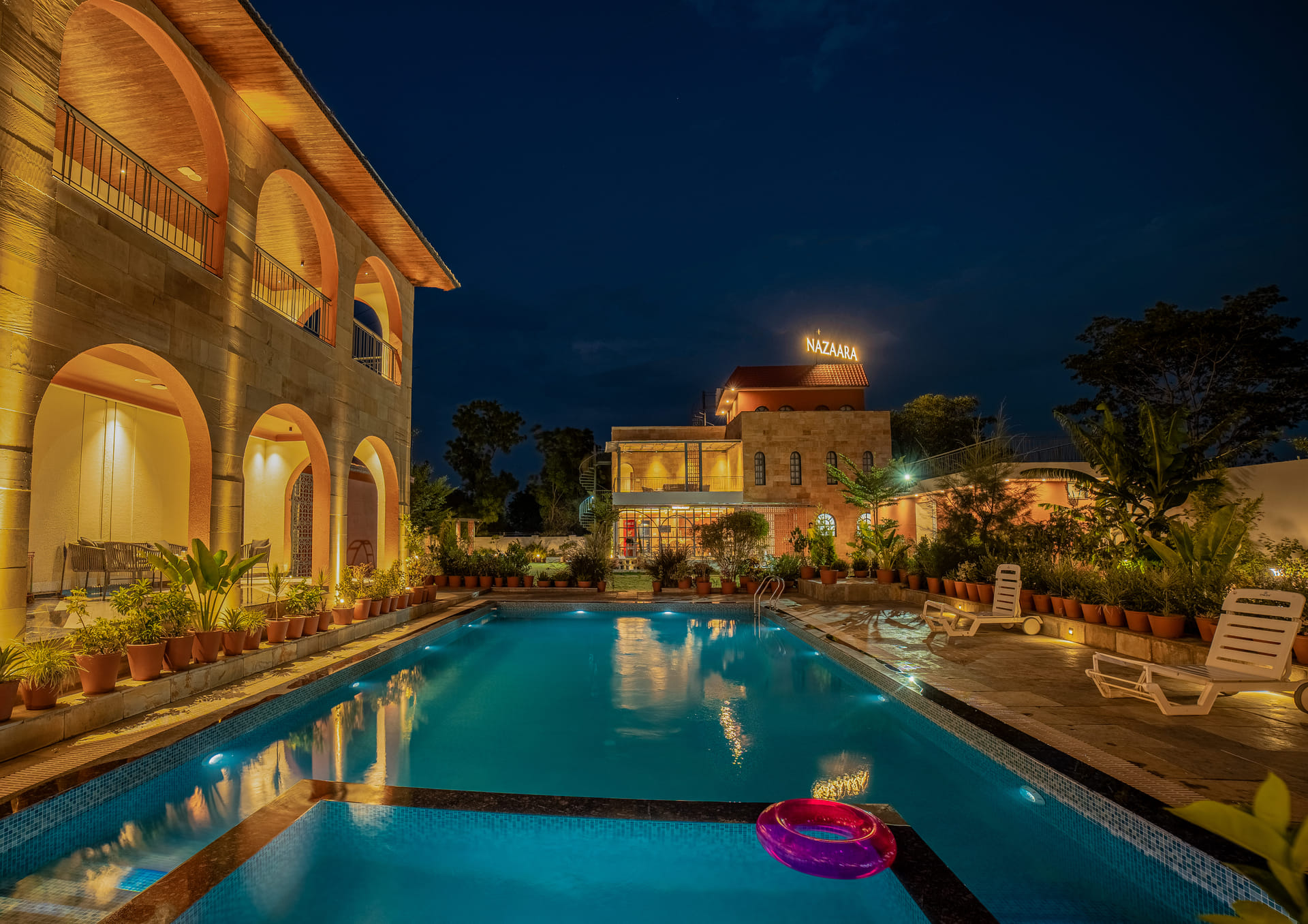 Pool courtyard framed by the arched facade at Nazaara Hills Retreat, Udaipur